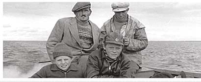 Fishermen travel by motorboat to sell fish in the shops of Inari. In the photo, Einari and Eenok Seurujrvi, Uula Saijets and Vilho Seurujrvi. Siida, Pentti Krkkinens archives.